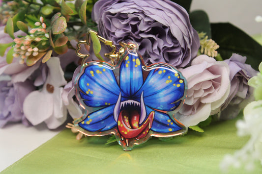 Acrylic Charm of a Blue Orchid with teeth and tongue on a floral background